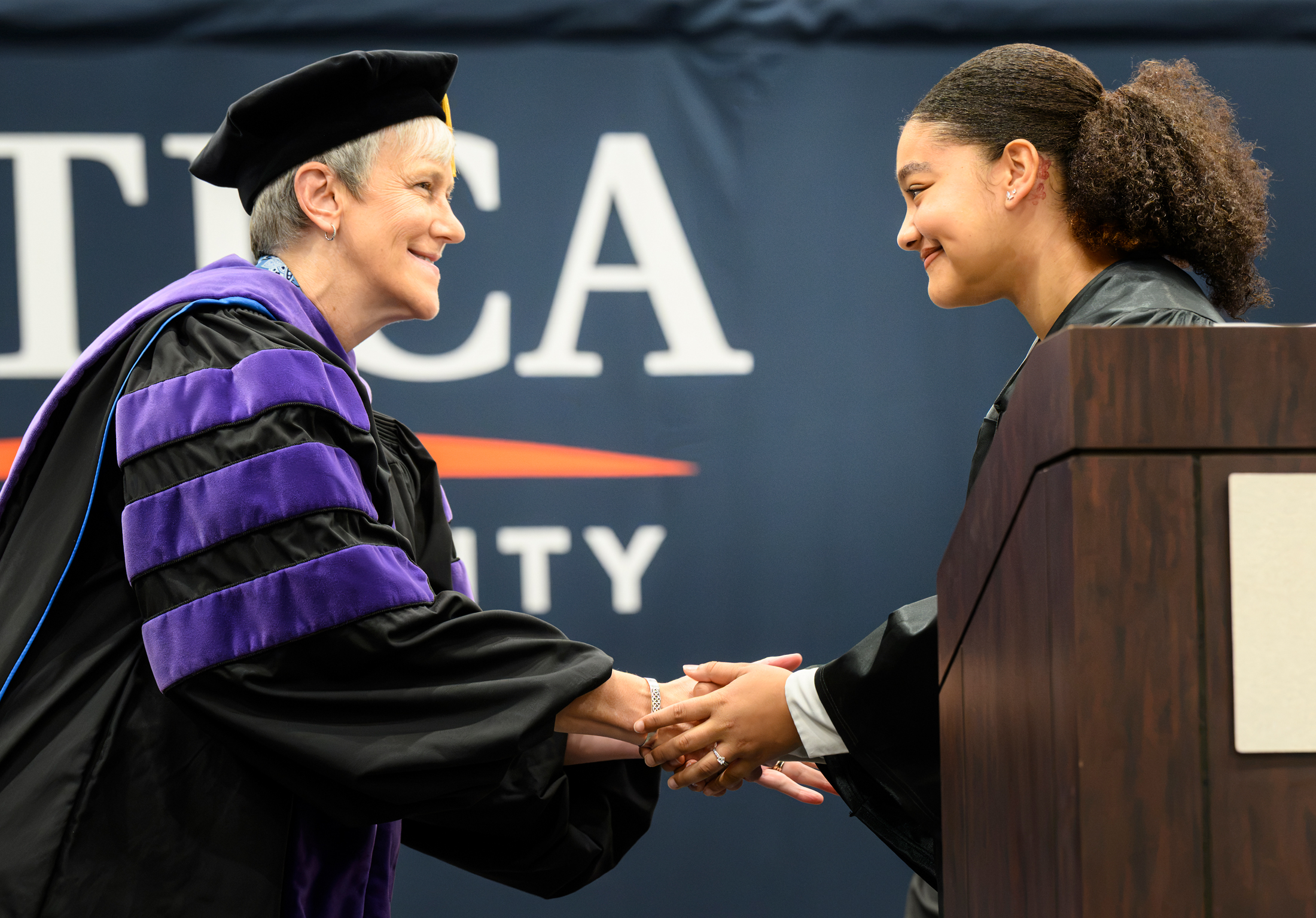 President Stephanie Nesbitt shakes hands with Evelyn Enriquez '27.