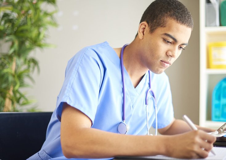 nurse writing in chart