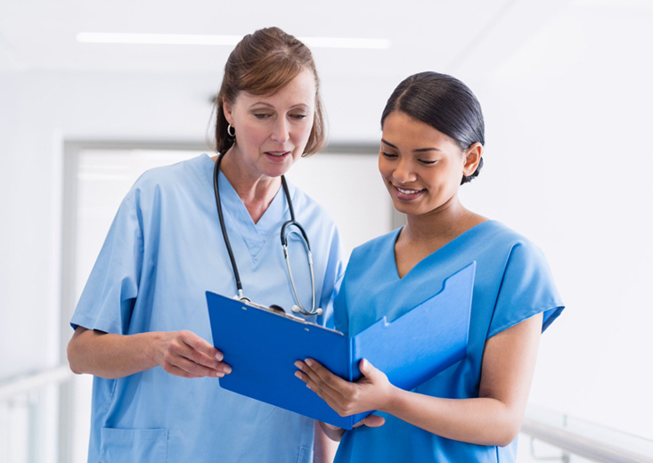 nursing student reviewing chart with nurse educator