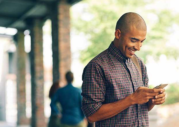 man smiling at phone in his hand