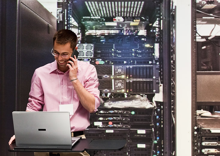 cybersecurity operations student in server room with laptop